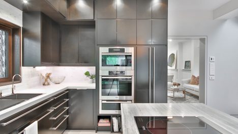 Moderni virtuvė su pilku interjeru įmontuota buitinė technika.